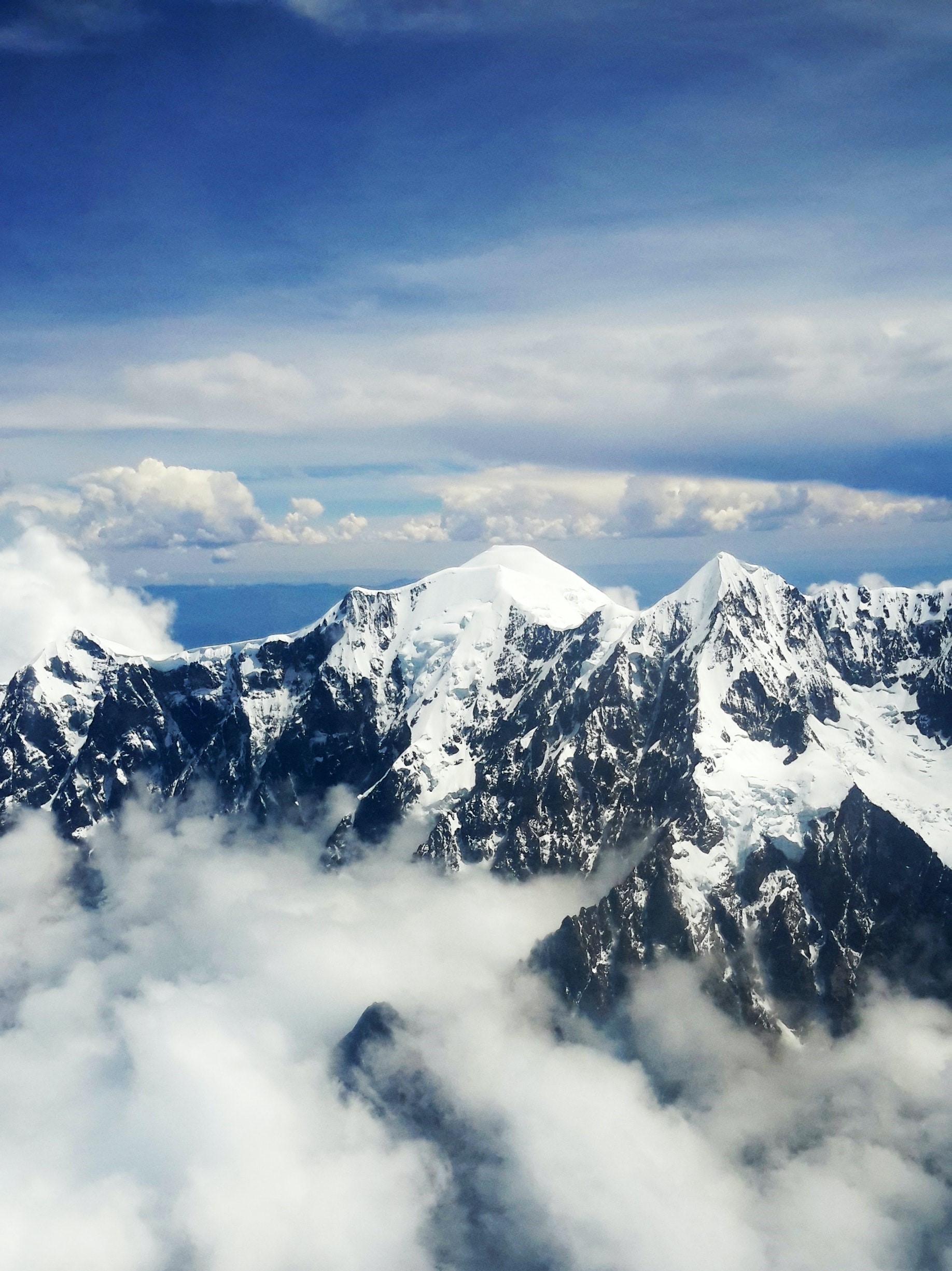 Alpina toppar med blå himmel